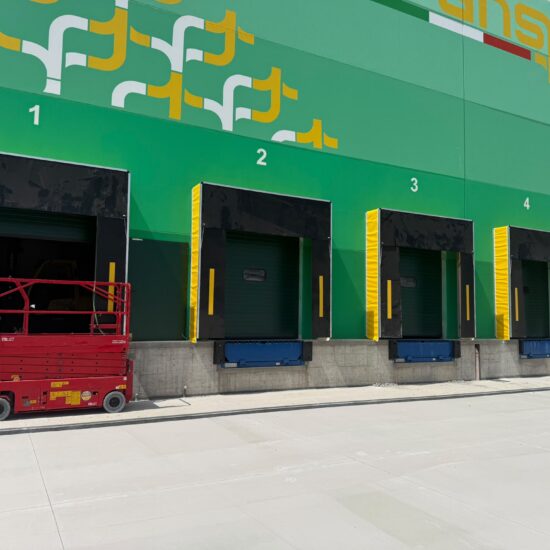 Sistemi per la logistica e punti di carico con portoni sezionali e baie isotermiche per lo stabilimento TransIsole